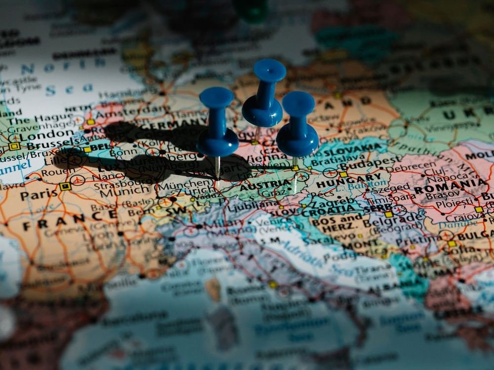Three blue push pins on a map of central Europe, with Germany, Austria and Hungary visible